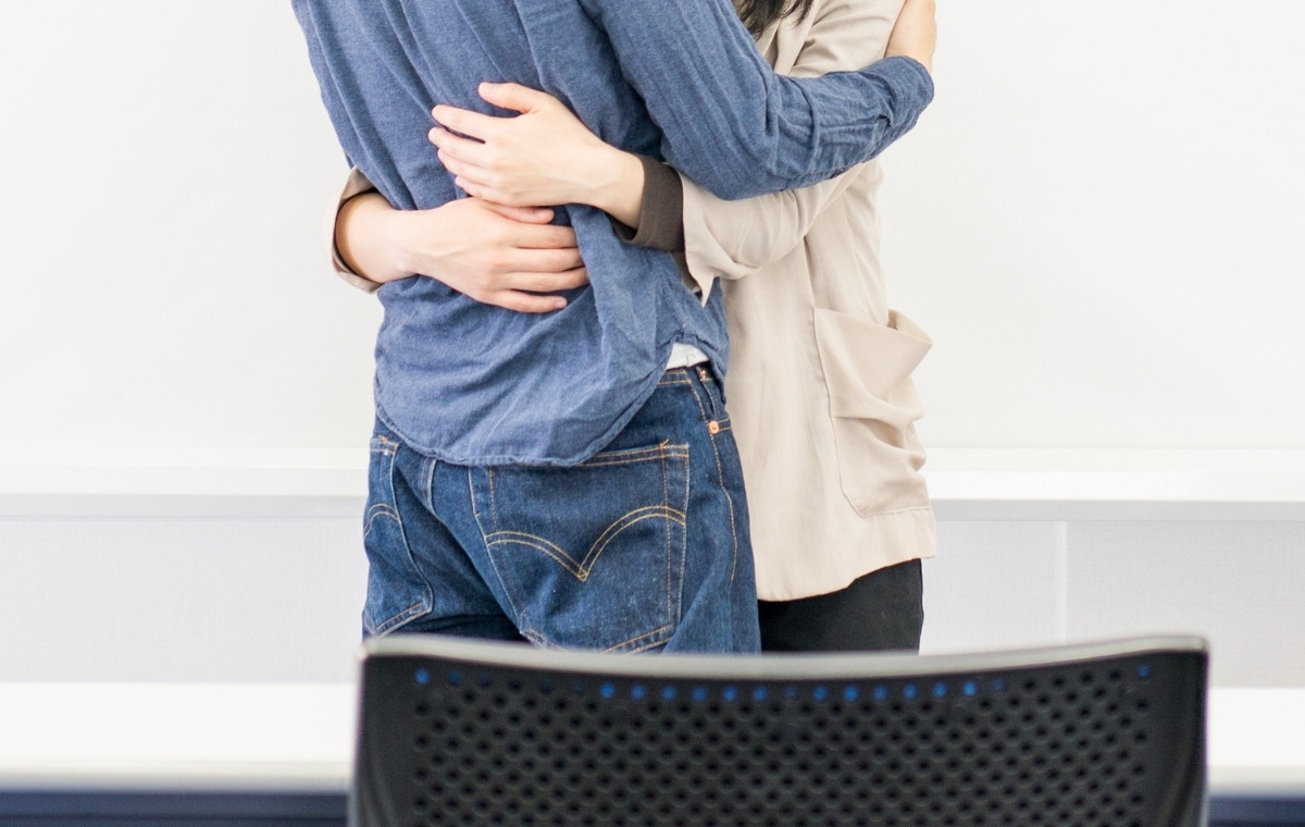 オフィスで抱き合う男女の写真