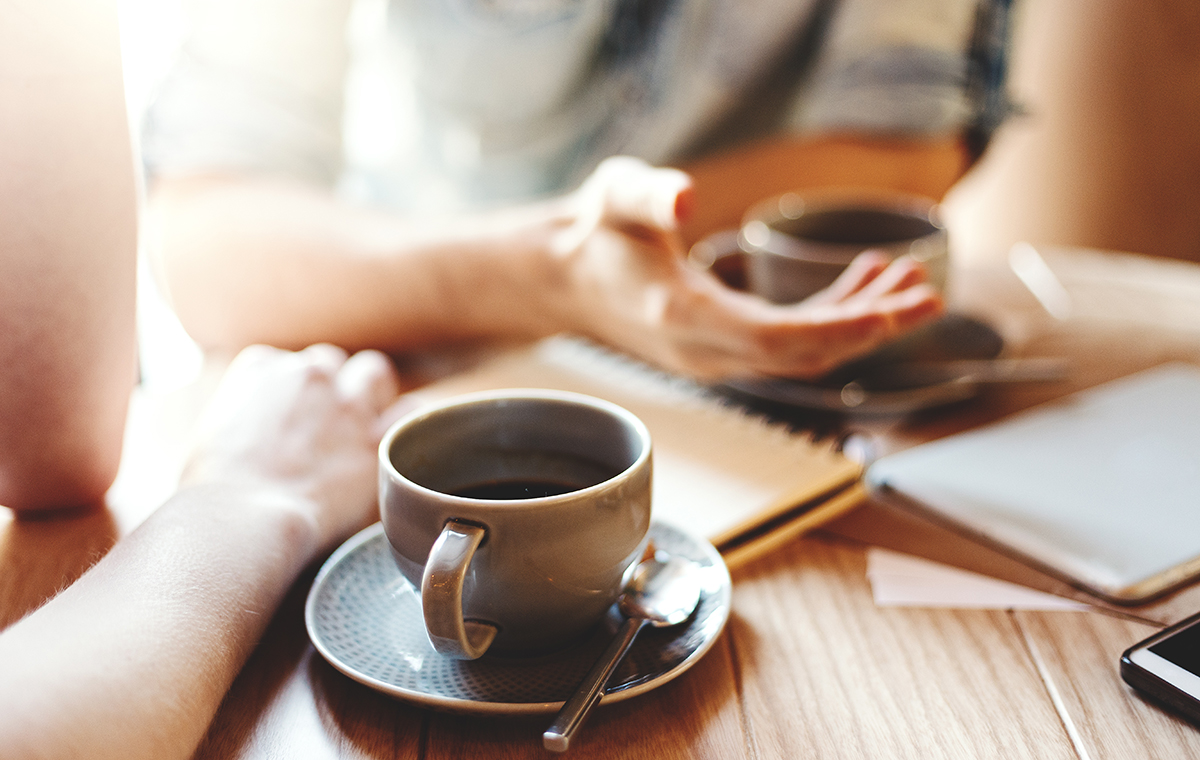 コーヒーカップと会話をする男性と女性