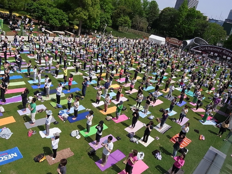 天気のいい屋外でヨガをしている人々の写真