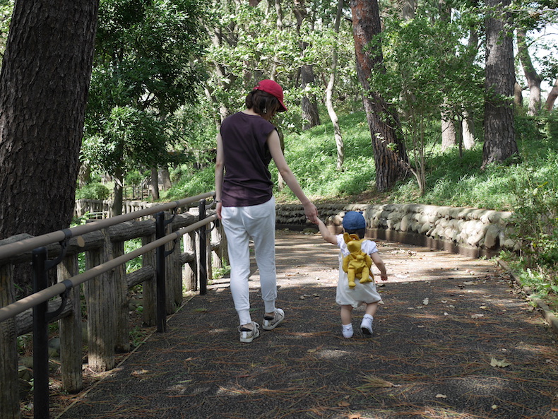 子供と手を繋いで歩いている女性の後ろ姿の写真