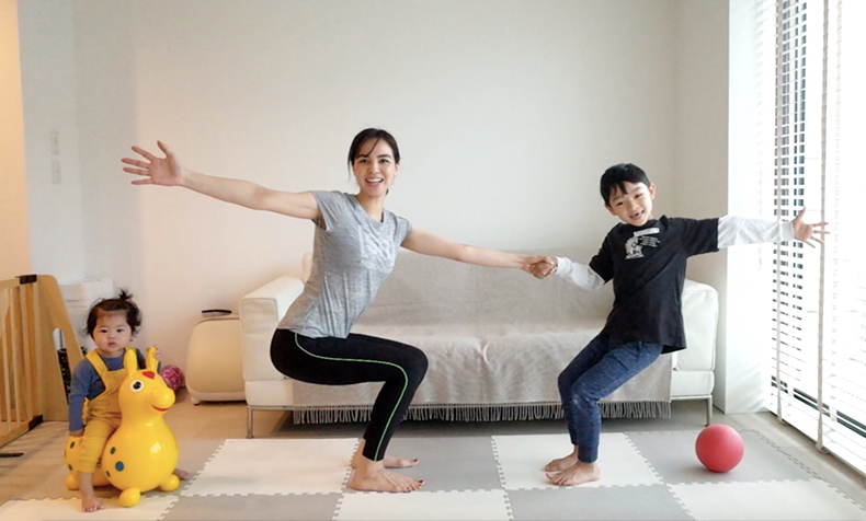 親子で実践する折りたたみ椅子のポーズの写真