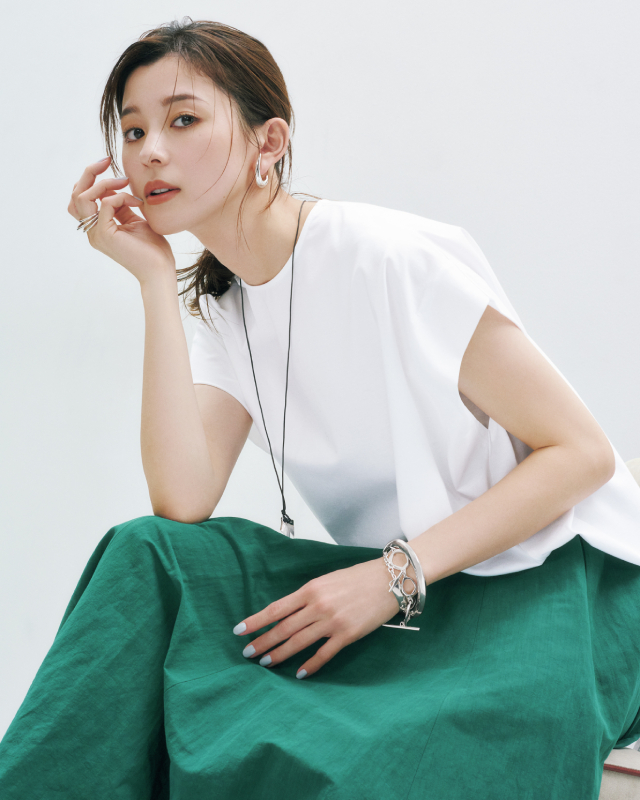白のフレンチスリーブTシャツ×グリーンのフレアスカートコーデのアップショット