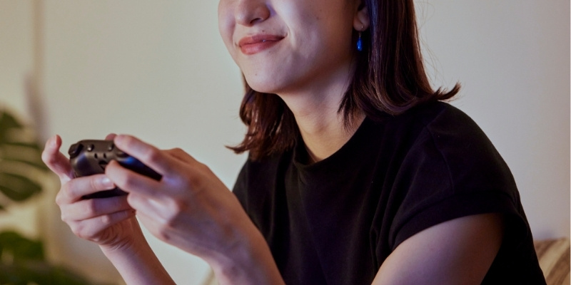 自宅でゲームを楽しむ女性の写真