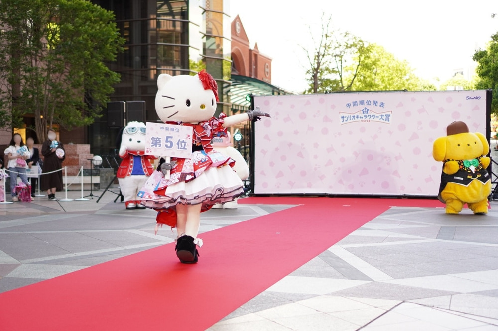 ランウェイを歩きながらポーズをとるハローキティの写真