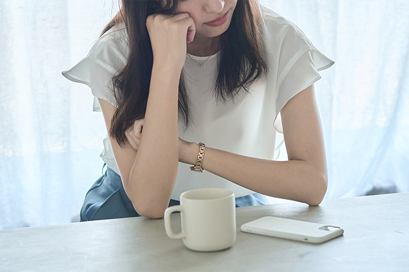 肘をついて考え込む女性
