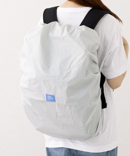 リュックカバーをつけている人の後ろ姿