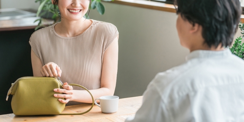 カフェで笑顔で会話する男女の写真
