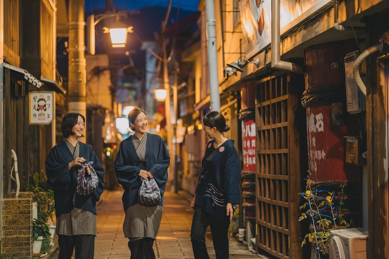 別府の温泉街を歩いている人々の写真