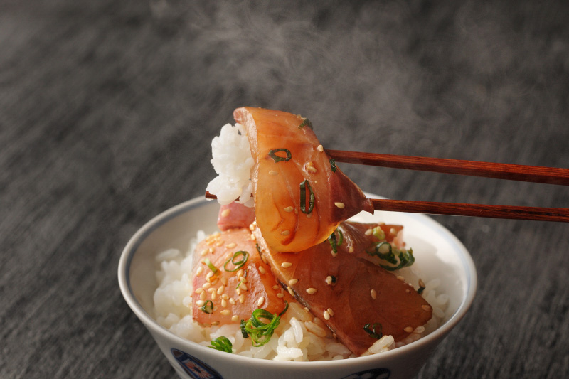 りゅうきゅうをご飯にのせている写真