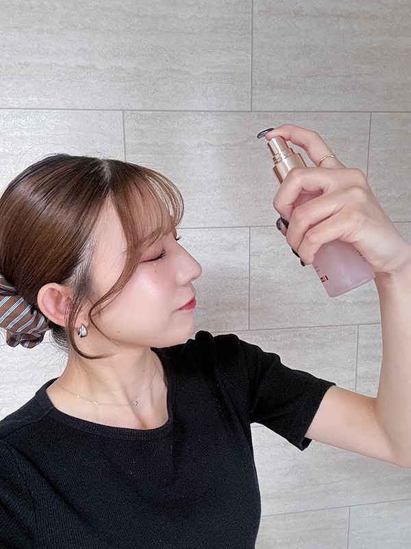 ミストを顔に吹きかける女性