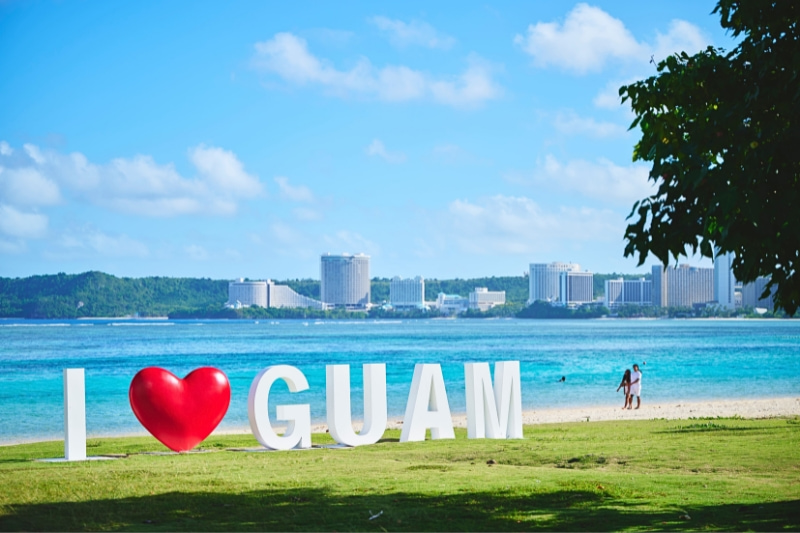 I♡GUAMというオブジェが置かれているグアムの海岸の写真