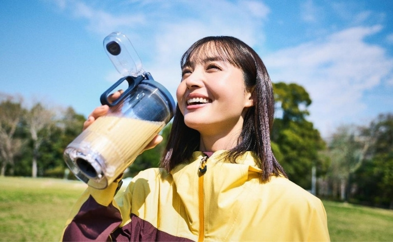 ボトルからスムージーを飲んでいる女性の写真