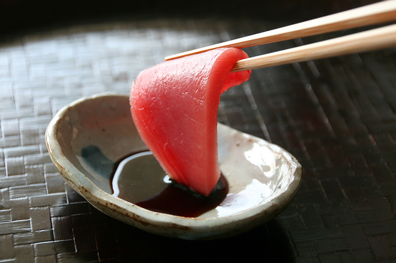 マグロを醤油につけて食べる様子