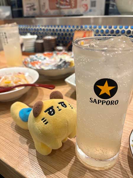居酒屋のカウンターで、東京ばな奈のキャラクター「ばにゃ奈」と“ぬい撮り”