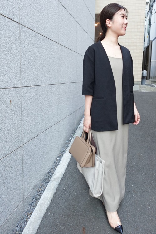 ワンピースとジャケットを着る宮本萌さん