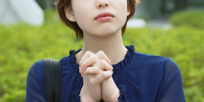 祈るポーズをとっている女性の写真