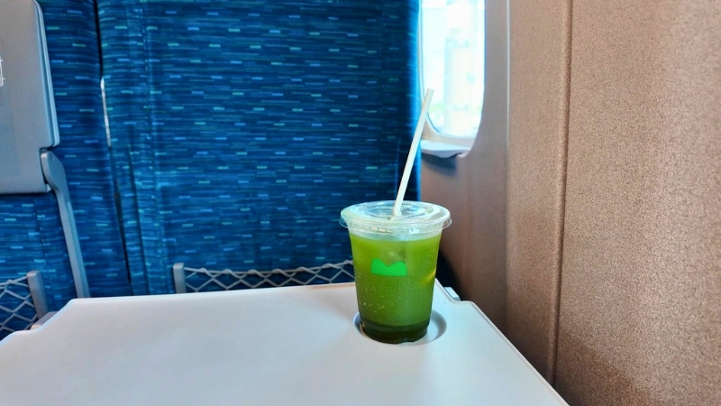 新幹線の座席テーブルに置かれたドリンクの写真