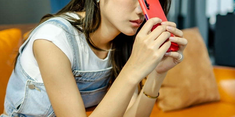 スマホを額に当ててうなだれる女性の写真