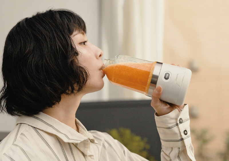 ブレンダーからジュースを飲んでいる人