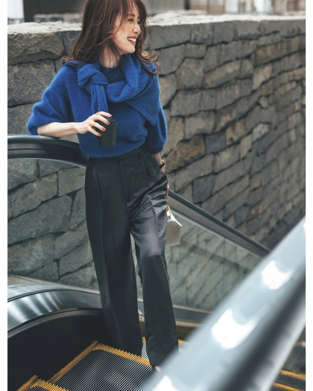 ロイヤルブルーのニット×肩に掛けたブルーのカーディガン×黒パンツコーデ