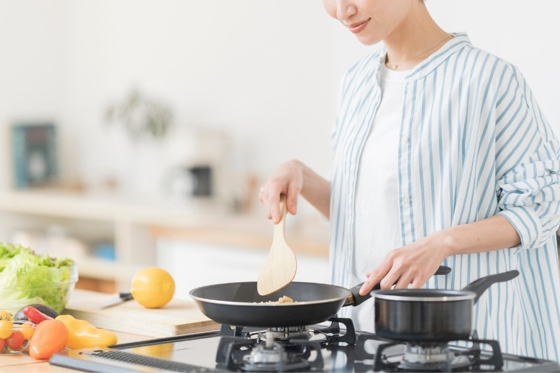 フライパンで料理している女性の写真
