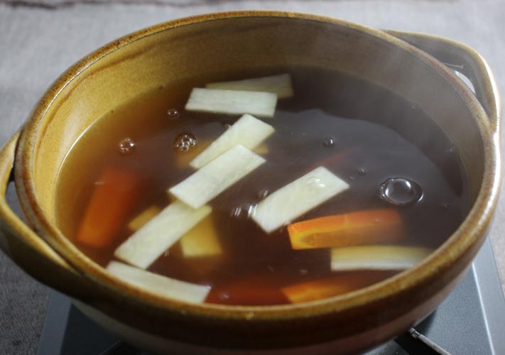 つゆを温めながら食材を加え、じっくり煮る。